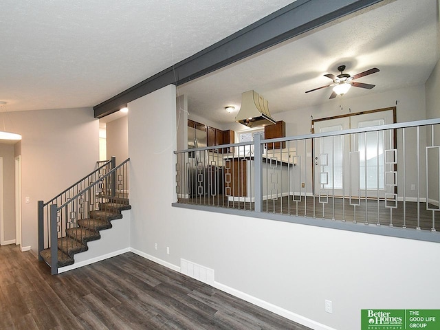 stairs with hardwood / wood-style floors, a textured ceiling, and ceiling fan