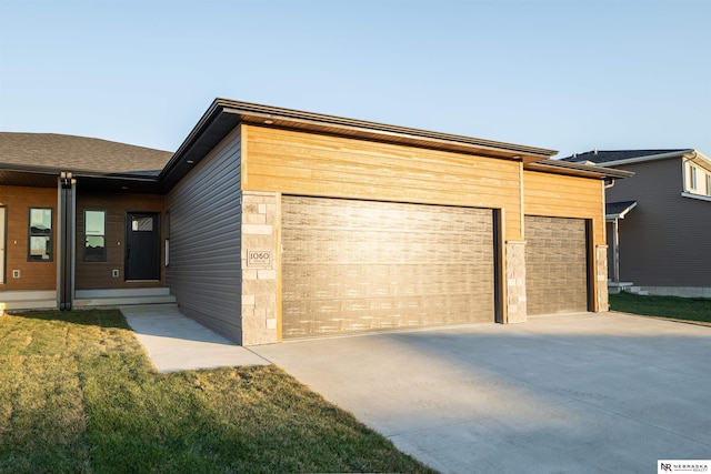 view of front of house featuring stone siding, concrete driveway, and an attached garage