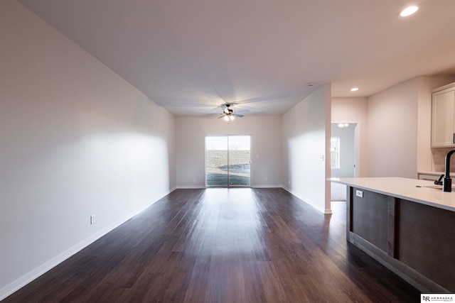 interior space with ceiling fan, sink, and dark hardwood / wood-style flooring