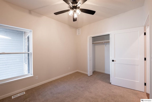 unfurnished bedroom featuring light carpet, ceiling fan, and a closet