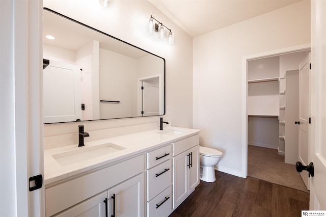 bathroom with hardwood / wood-style flooring, vanity, and toilet