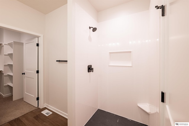 bathroom featuring hardwood / wood-style flooring and walk in shower