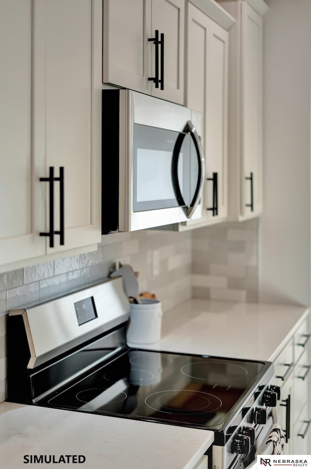 kitchen featuring white cabinetry, tasteful backsplash, appliances with stainless steel finishes, and light countertops