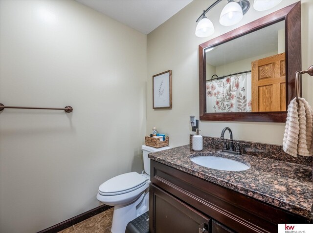 bathroom featuring tile patterned flooring, vanity, and toilet