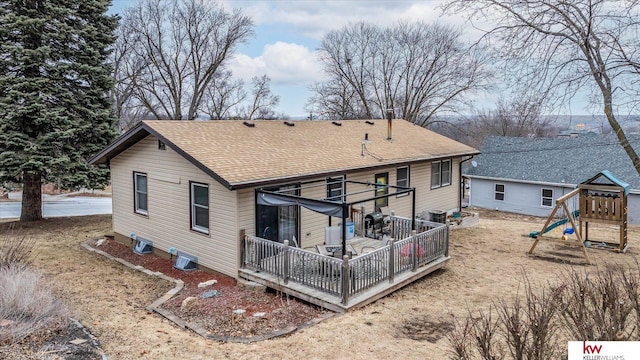 rear view of house featuring central AC unit, a playground, and a deck