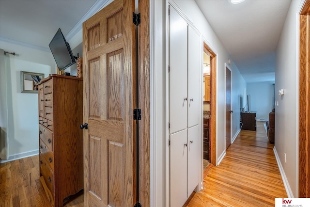 corridor featuring ornamental molding and light wood-type flooring