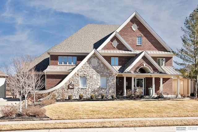 view of front of property featuring metal roof, a standing seam roof, stone siding, and a front lawn