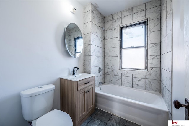 full bathroom featuring vanity, tiled shower / bath combo, and toilet