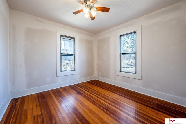 spare room with ceiling fan, plenty of natural light, and hardwood / wood-style floors