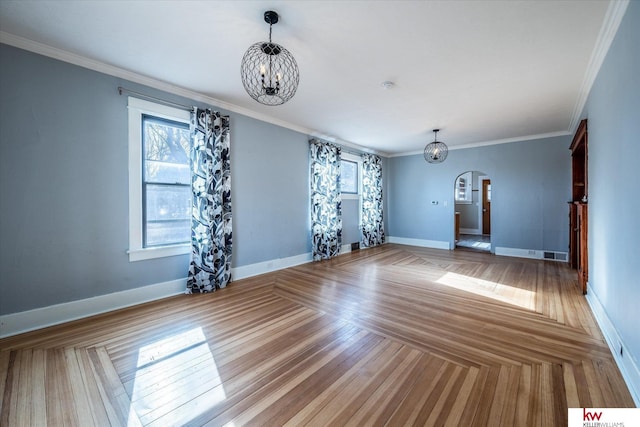 unfurnished living room featuring an inviting chandelier, hardwood / wood-style floors, and crown molding