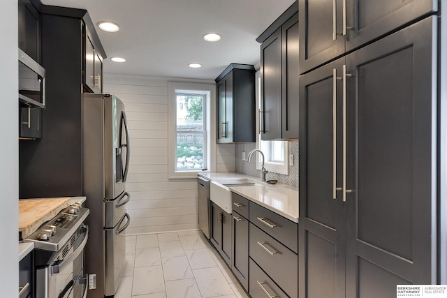 kitchen with appliances with stainless steel finishes, sink, and decorative backsplash