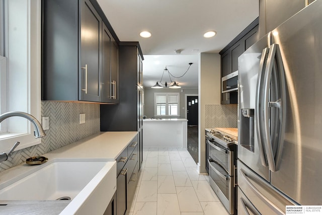 kitchen with tasteful backsplash, sink, and appliances with stainless steel finishes