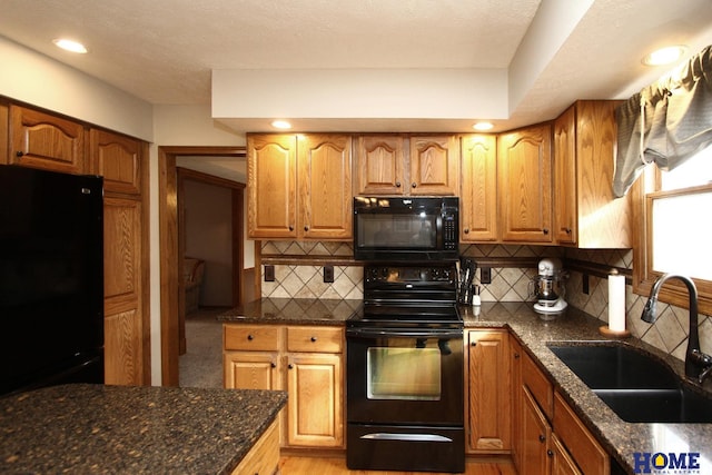 kitchen with tasteful backsplash, sink, dark stone counters, and black appliances