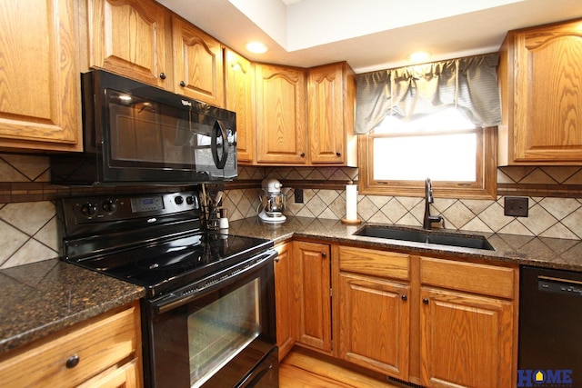 kitchen with tasteful backsplash, dark stone countertops, sink, and black appliances