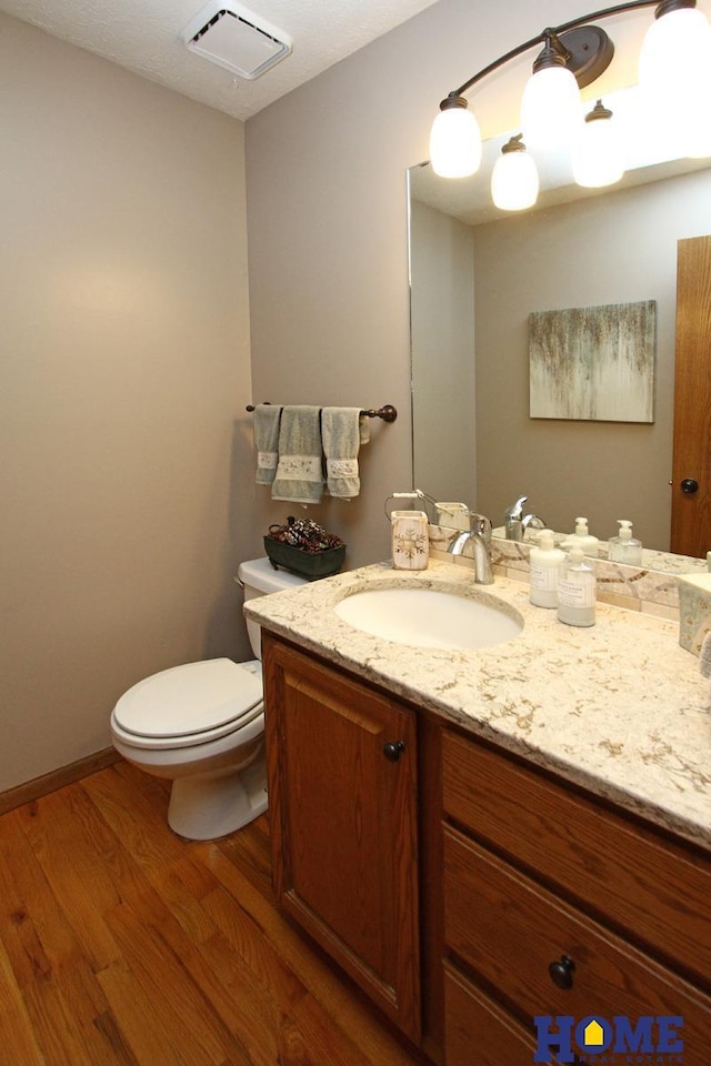 bathroom featuring vanity, toilet, and hardwood / wood-style floors