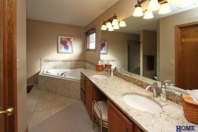 bathroom with vanity, tiled bath, tile patterned floors, and toilet