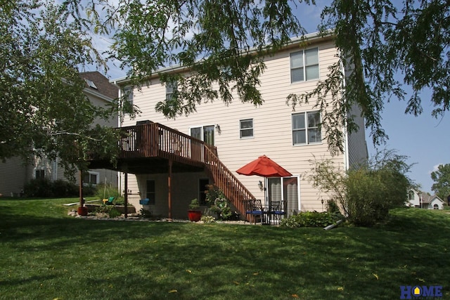 rear view of house with a wooden deck and a lawn