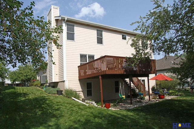 rear view of property featuring a wooden deck and a lawn