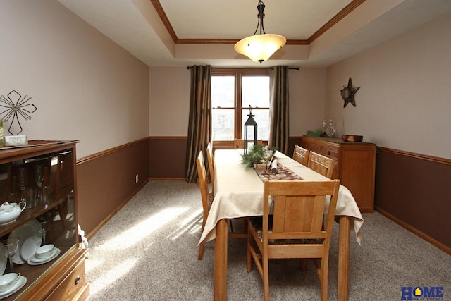 dining area featuring crown molding, a tray ceiling, and carpet