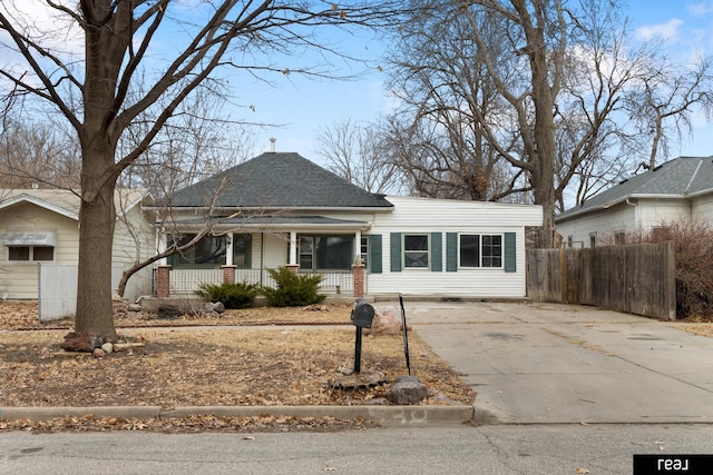 view of front of home featuring fence, a porch, driveway, and a shingled roof