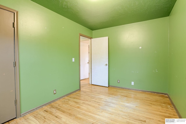 unfurnished bedroom featuring a textured ceiling and light hardwood / wood-style floors