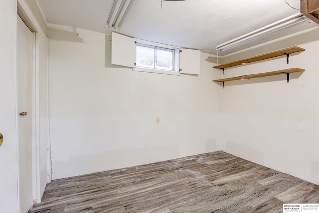 basement featuring hardwood / wood-style floors and a textured ceiling