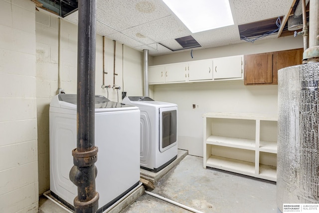 clothes washing area featuring cabinets and washing machine and clothes dryer