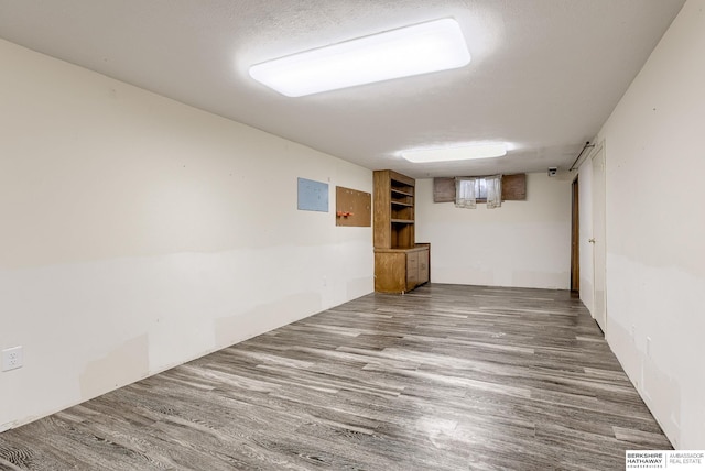 basement featuring hardwood / wood-style floors and a textured ceiling