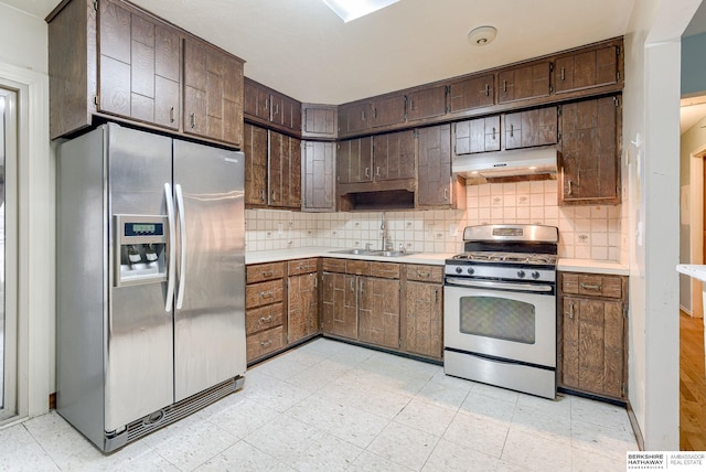 kitchen featuring tasteful backsplash, sink, dark brown cabinets, and stainless steel appliances