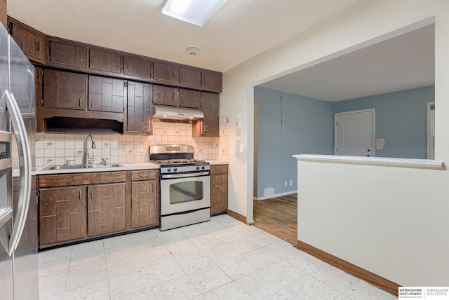 kitchen with tasteful backsplash, sink, stainless steel appliances, and dark brown cabinetry