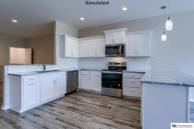 kitchen with white cabinetry, stainless steel appliances, and kitchen peninsula