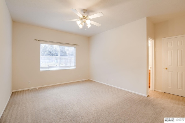 empty room with ceiling fan and light carpet