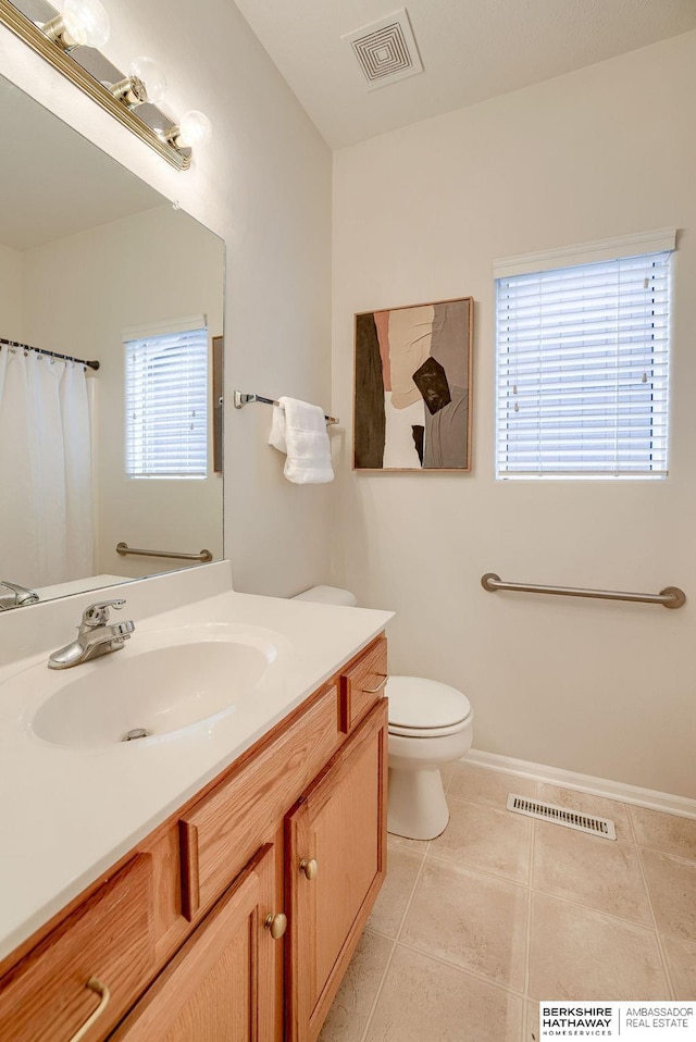 bathroom featuring vanity, tile patterned floors, and toilet