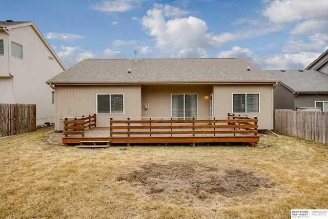 back of property with a wooden deck and a yard