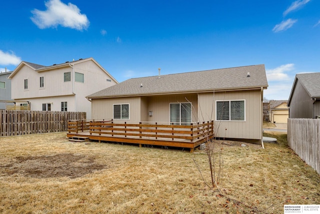 rear view of property with a wooden deck and a yard