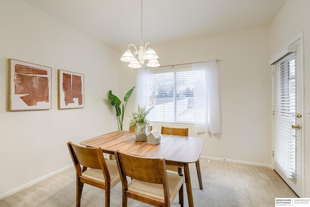 dining area with light carpet and a notable chandelier