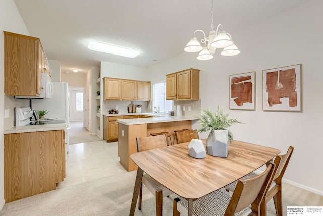 carpeted dining area featuring sink and a notable chandelier