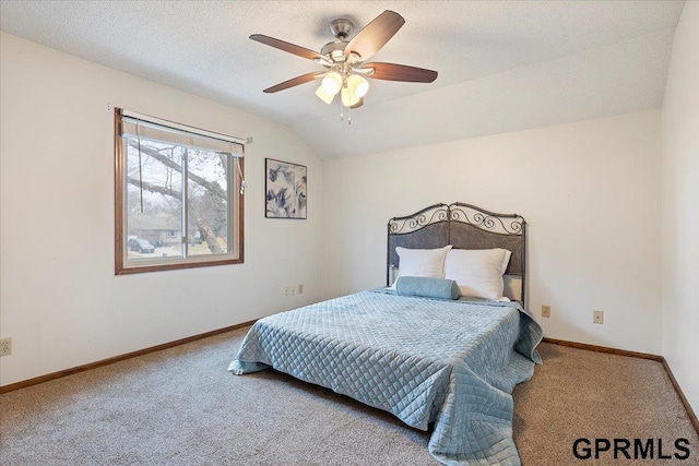 carpeted bedroom with ceiling fan, vaulted ceiling, and a textured ceiling