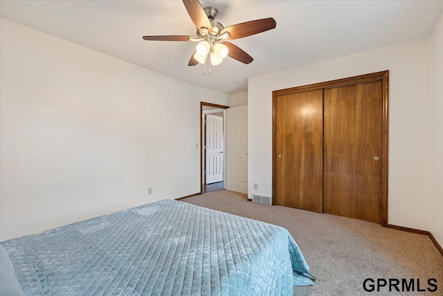 unfurnished bedroom featuring ceiling fan, carpet flooring, and a closet