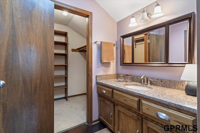 bathroom with vanity and vaulted ceiling