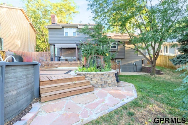 rear view of house with a patio, a deck, and a lawn