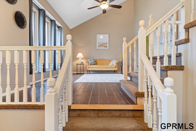 staircase with high vaulted ceiling, hardwood / wood-style floors, and ceiling fan