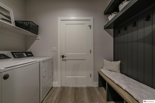 laundry room featuring separate washer and dryer and light hardwood / wood-style flooring