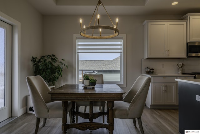 dining space featuring an inviting chandelier and light wood-type flooring