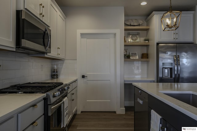 kitchen featuring white cabinetry, appliances with stainless steel finishes, pendant lighting, and light stone counters