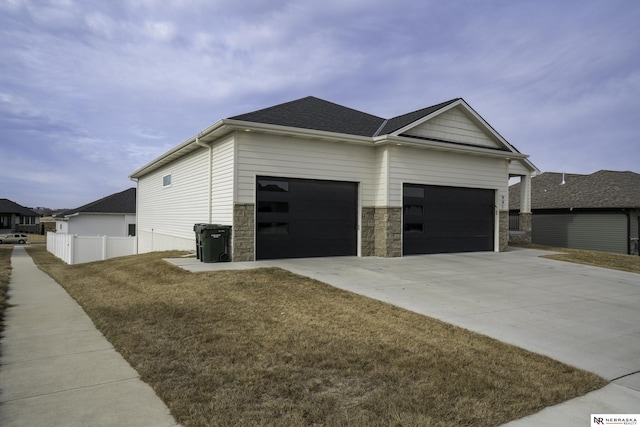 view of side of home with a garage and a lawn