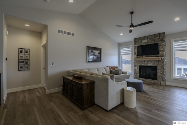 living room with a stone fireplace, a healthy amount of sunlight, and hardwood / wood-style floors