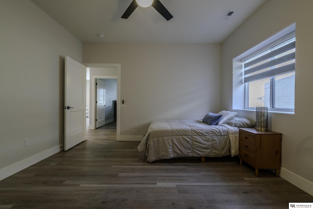 bedroom with dark hardwood / wood-style floors and ceiling fan