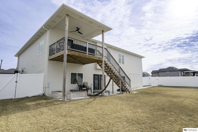 back of house featuring a wooden deck and a lawn