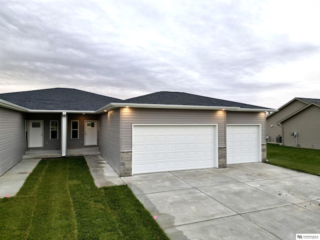 single story home with a garage and a front lawn